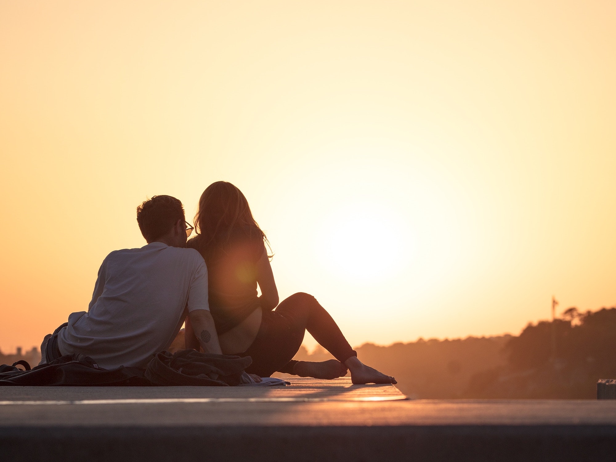 Happy couple sitting in sunset